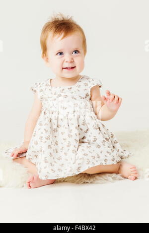 little girl sitting on the sheep's clothing. Stock Photo