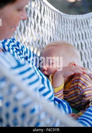 Mum with sleeping son in her lap. Stock Photo