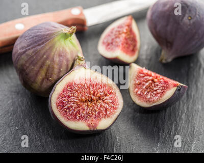 Ripe fig fruits on the graphite cutting board. Stock Photo