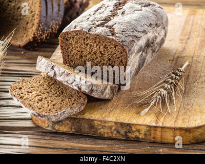 Sliced black bread on the old wooden plank. Stock Photo