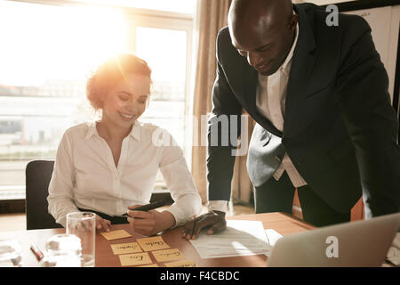 Young business colleagues in conference room discussing manpower resources. Businesswoman sitting with names on adhesive notes a Stock Photo