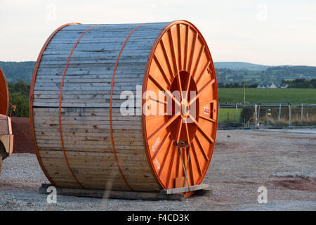 Large orange cable drum to be used for underground link from an offshore windfarm to UK National Grid hub. Stock Photo