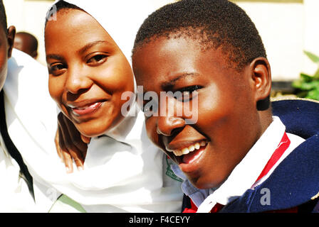 Tanzania, Mwanza, Muslim and Christian students hugging as friends Stock Photo