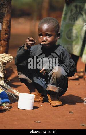 Tanzania, Refugee Camp, Congolese boy eats his morning porridge. (Large format sizes available) Stock Photo