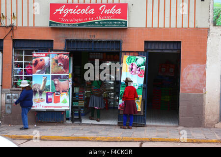 Quechua women entering a shop selling fertilizers and agricultural products, Cusco, Peru Stock Photo