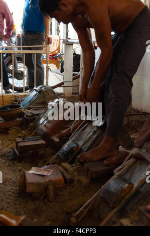 Young craftsman punching gold with a hammer Stock Photo