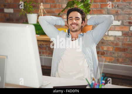 Smiling man relaxing at office desk Stock Photo