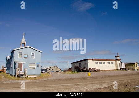 Canada, Nunavut, western shore of Hudson Bay, Kivalliq Region, Arviat. Mikilaaq Parish Center (blue) and Catholic Church (right). Stock Photo
