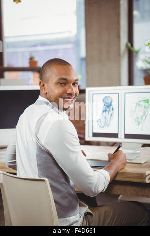 Smiling cartoonist writing on notepad Stock Photo