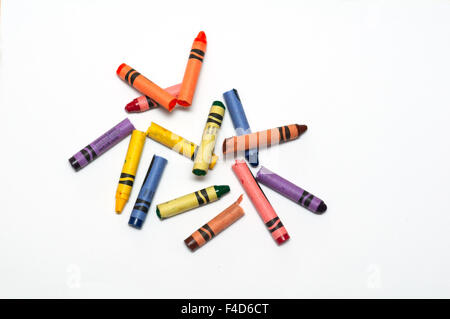 broken crayons laying on a white sheet of paper Stock Photo