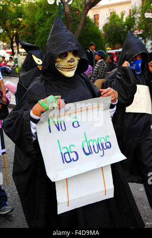 La Paz, Bolivia, 16th October 2015. A student dressed as Death carries a placard saying 'No to Drugs' during a march through La Paz city centre warning of the dangers of drug use. The demonstration is organised every year by the police together with schools and colleges to educate and raise awareness about drugs and their dangers. Credit: James Brunker / Alamy Live News Stock Photo