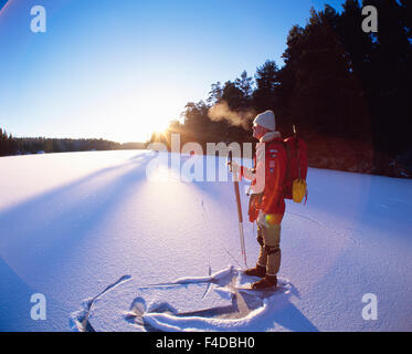 Man standing on snowy ground with skis Stock Photo