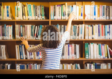 Pretty student in library taking book Stock Photo
