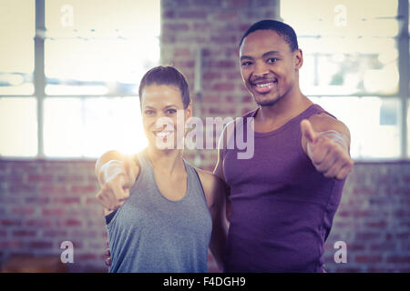 Fit couple smiling gesturing thumbs up Stock Photo