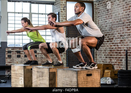 Fit people doing squat jumps Stock Photo