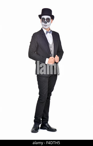 full length portrait of an elegant man with calaveras makeup, wearing jacket, bow tie and top hat, on a white background Stock Photo