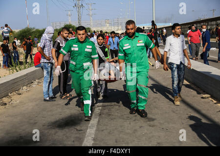 Erez, Gaza. 16th Oct, 2015. Palestinians carry a wounded youth, during clashes with Israeli soldiers securing the entrance of the Erez border crossing between Gaza Strip and Israel, in the northern Gaza Strip. © Nidal Alwaheidi/Pacific Press/Alamy Live News