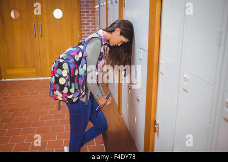 Stressed student leaning head on locker Stock Photo