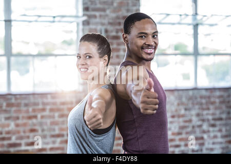 Fit couple smiling gesturing thumbs up Stock Photo