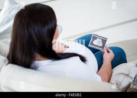 Smiling pregnant woman holding sonogram Stock Photo