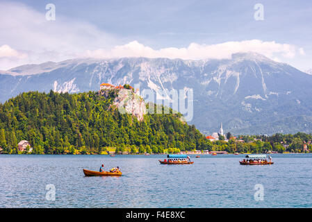BLED, SLOVENIA - AUGUST 1, 2015 - Bled Castle on a Precipice Overlooking Bled Lake with Tourists and Boats on August 1, 2015 in Stock Photo
