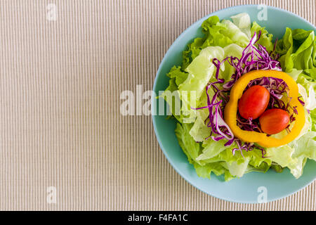 Salad with various kind of vegetables in bowl on table. Stock Photo
