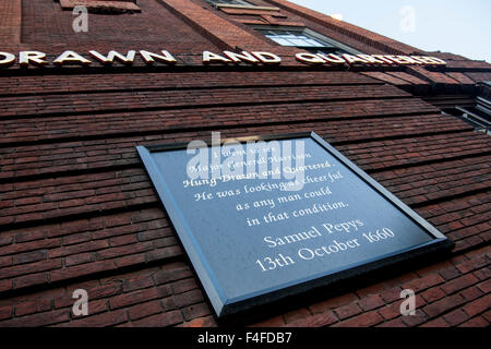 Hung Drawn and Quartered pub with Samuel Pepys quote on board on exterior wall City of London England UK Stock Photo