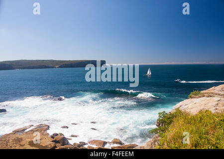 View from South Head to North Head with yacht passing out of Harbour to Pacific Ocean rough water in foreground Sydney New South Stock Photo