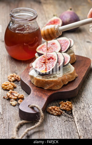 bread with figs, ricotta, honey, walnut  on a cutting board Stock Photo