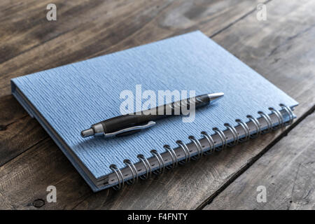Blue notebook and pen on wooden table, close up Stock Photo