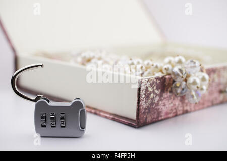 Opened number lock and opened jewelery box on background Stock Photo