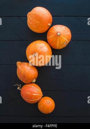 Ripe pumpkins over black rustic wooden backdrop, top view, copy space Stock Photo