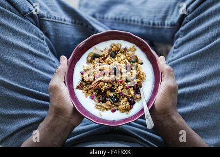 A bowl of Spicy Pumpkin Granola is in the hands of a man. Stock Photo