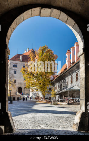 Autumn view of forecourt of Cesky Krumlov Castle framed in entrance arch Stock Photo