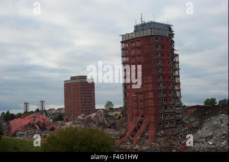 Glasgow, Scotland 11th of October 2015. The demolition of the Red Road Flats that were partially demolished is currently being demolished with heavy machinery due to the two remaining towers that did not fully come down with the explosion. Piles of rubble are in place of where the towers stood. The two remaining towers are leaning slightly after only being partially demolished. Credit:  Andrew Steven Graham/Alamy Live News Stock Photo