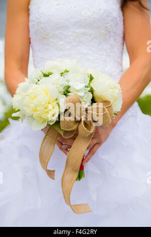 White flowers in a bouquet held by the bride on her wedding day. Stock Photo