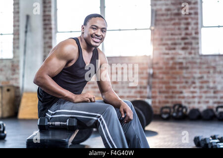 Muscular man sitting on a bench workout Stock Photo