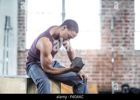 Serious muscular man lifting dumbbell Stock Photo