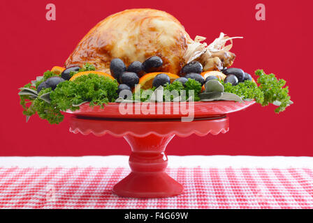 Red and white theme Thanksgiving Table setting with Roast Turkey Chicken on large platter centerpiece. Stock Photo