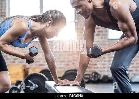 Fit couple doing dumbbell exercises Stock Photo