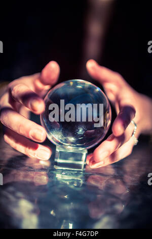 Cropped hands of fortune teller using crystal ball Stock Photo