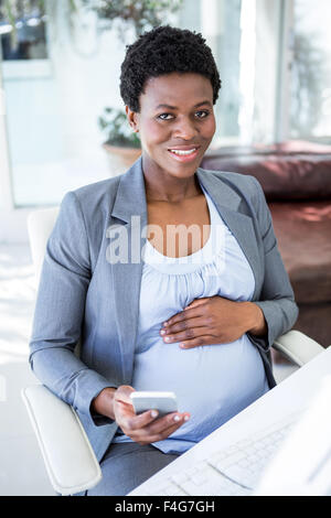 Smiling pregnant businesswoman at work Stock Photo