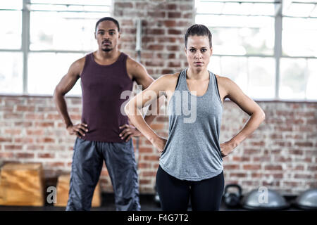 Fit couple posing with hands on hips Stock Photo