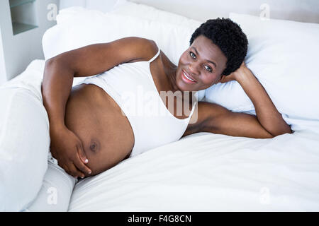 Pregnant woman lying in bed Stock Photo