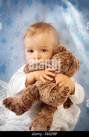 One year old baby holding a teddy bear Stock Photo
