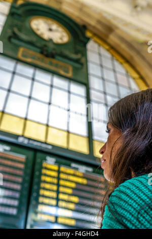 Woman reads the train schedule in Sao Bento railway station. October, 2015. Porto, Portugal. Stock Photo
