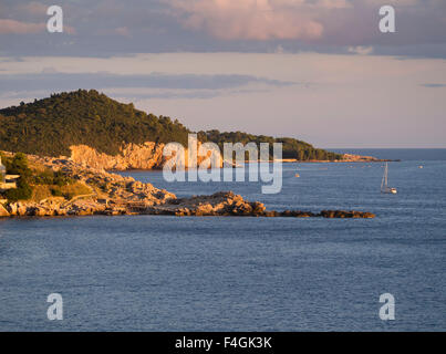 Sunset on the Dalmatian coast of the Adriatic sea makes the cliffs turn golden , here the outskirts of Dubrovnik Croatia Stock Photo