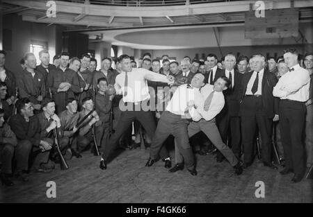 JACK DEMPSEY American boxer at left 'spars' with illusionist Harry Houdini who is held up by champion lightweight  boxer Benny Leonard. Photo Bain News service about 1920 Stock Photo