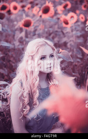 Beautiful blond woman in a sunflower field Stock Photo