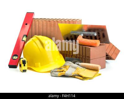 Perforated bricks, stainless steel trowel, yellow helmet, protective gloves and spirit level isolated on white Stock Photo